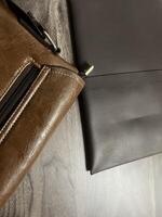 Leather bag with gadgets and notebooks on Wooden Work Desk photo
