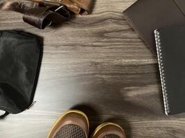 Leather bag with gadgets and notebooks on Wooden Work Desk photo