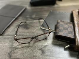 Leather bag with gadgets and notebooks on Wooden Work Desk photo