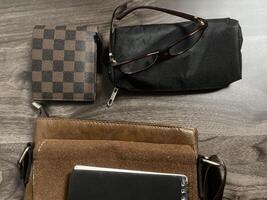 Leather bag with gadgets and notebooks on Wooden Work Desk photo