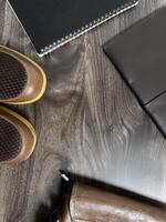 Leather bag with gadgets and notebooks on Wooden Work Desk photo