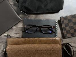 Leather bag with gadgets and notebooks on Wooden Work Desk photo