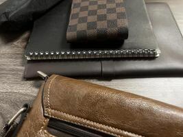 Leather bag with gadgets and notebooks on Wooden Work Desk photo