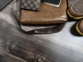 Leather bag with gadgets and notebooks on Wooden Work Desk photo