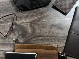Leather bag with gadgets and notebooks on Wooden Work Desk photo