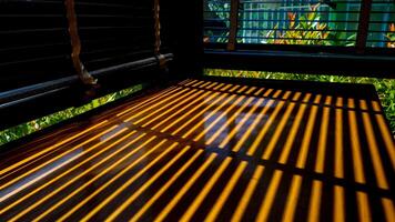 Sunlight Casting Striped Shadows Through Window Blinds onto Wooden Table in a Cozy Room photo