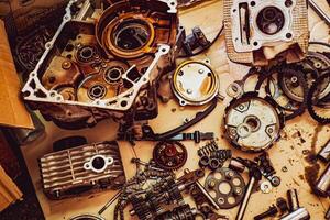Disassembled Engine Parts and Mechanical Components on a Workbench in a Garage Workshop photo