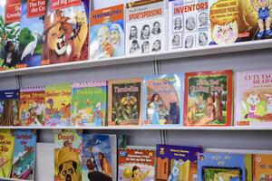 New Delhi, India, July 17 2024 - Variety of Books on shelf inside a book-stall at Delhi International Book Fair, Selection of books on display in Annual Book Fair at Bharat Mandapam complex photo