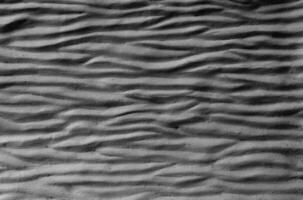 black cement wall curved with wave pattern. Modern design of black wavy background photo
