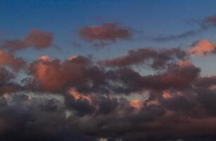 Dramatic clouds in the blue sky in the morning, the rising sun rays hitting the clouds photo