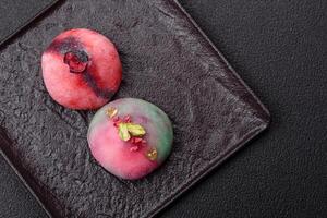 Delicious cold Japanese mochi dessert with colorful rice dough shell and fruit filling photo