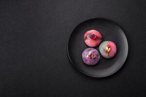Delicious cold Japanese mochi dessert with colorful rice dough shell and fruit filling photo