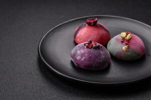 Delicious cold Japanese mochi dessert with colorful rice dough shell and fruit filling photo