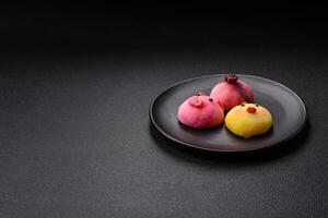 Delicious cold Japanese mochi dessert with colorful rice dough shell and fruit filling photo