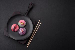 Delicious cold Japanese mochi dessert with colorful rice dough shell and fruit filling photo