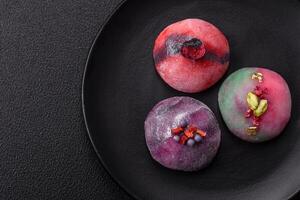 Delicious cold Japanese mochi dessert with colorful rice dough shell and fruit filling photo