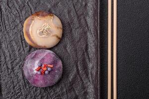 Delicious cold Japanese mochi dessert with colorful rice dough shell and fruit filling photo