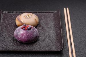 Delicious cold Japanese mochi dessert with colorful rice dough shell and fruit filling photo