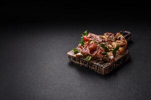 Variation of several toasts or bruschetta with prosciutto, mushrooms and veal photo