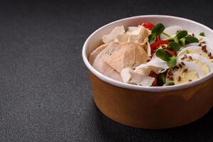 Delicious fresh caesar salad in a bowl with chicken breast, egg, tomatoes photo