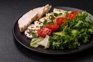 Delicious fresh caesar salad in a bowl with chicken breast, egg, tomatoes photo