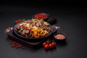 Bowl of food with beef, bulgur, tomatoes, mushrooms, zucchini photo