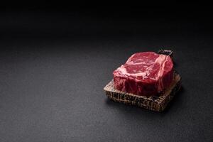 Fresh, raw beef steak with salt, spices and herbs photo