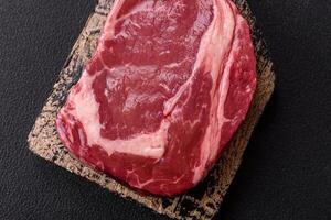 Fresh, raw beef steak with salt, spices and herbs photo