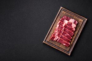Fresh raw beef cut into slices with salt, spices photo