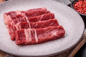 Fresh raw beef cut into slices with salt, spices photo