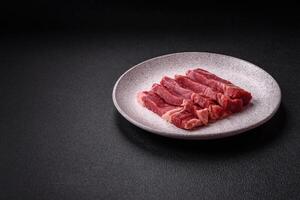 Fresh raw beef cut into slices with salt, spices photo