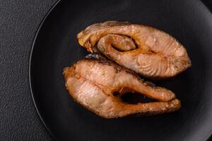 Delicious red salmon r trout fish grilled with spices and herbs photo