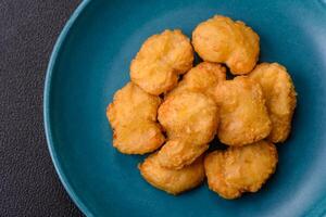 Delicious fresh crispy chicken nuggets on a dark concrete background photo