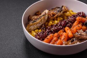 A colorful vegetarian dish consists of fish, beans, corn, mushrooms photo