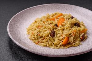 Delicious fresh pilaf with rice, carrots, meat, onions, spices and berries photo