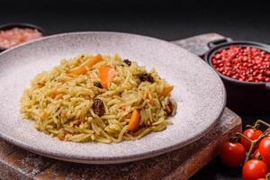 Delicious fresh pilaf with rice, carrots, meat, onions, spices and berries photo