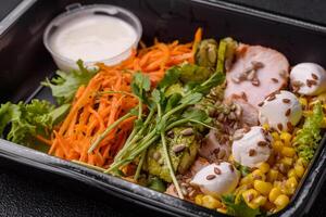 Fresh juicy salad with meat, mozzarella, carrots, lettuce, corn photo
