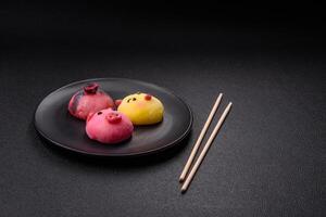 Delicious cold Japanese mochi dessert with colorful rice dough shell and fruit filling photo