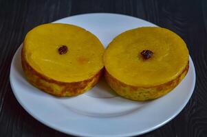Mud cake is a traditional Indonesian cake, made from potatoes, flour, sugar, eggs and coconut milk and then bake with raisins served on white plate. Selected focus. photo
