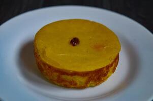 Mud cake is a traditional Indonesian cake, made from potatoes, flour, sugar, eggs and coconut milk and then bake with raisins served on white plate. Selected focus. photo