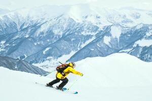 Close up dynamic sports banner of man skier on piste ski downhill fast motion in Alps. Active winter holidays, skiing downhill in overcast day. Ski rides on the track with swirls of fresh snow photo