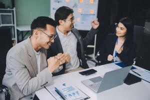 Group of colleagues engaging in a discussion during a business meeting in a conference room. Happy business people, men and women, collaborating and working towards their shared goals. photo