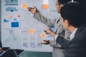 Group of confident business people point to graphs and charts to analyze market data, balance sheet, account, net profit to plan new sales strategies to increase production capacity. photo