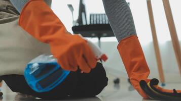 Woman cleaning table using rag and diffuser at home. photo