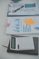 Charming Young asian businesswoman sitting on laptop computer in the office, making report calculating balance Internal Revenue Service checking document. photo