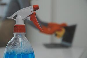 Woman cleaning table using rag and diffuser at home. photo