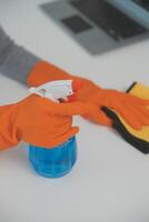 Woman cleaning table using rag and diffuser at home. photo