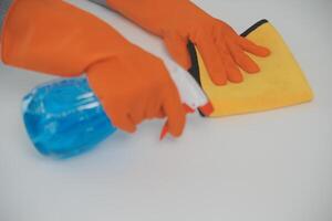 Woman cleaning table using rag and diffuser at home. photo