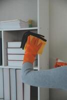 Woman cleaning table using rag and diffuser at home. photo