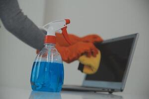 Woman cleaning table using rag and diffuser at home. photo